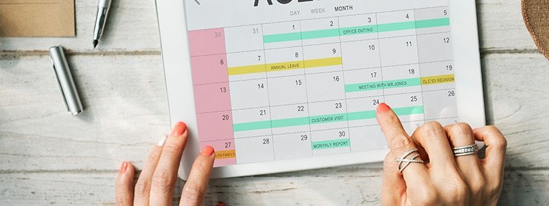 Manos sobre calendario revisando los feriados en Uruguay