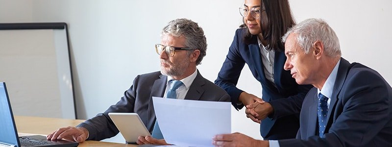 Tres abogados reunidos evaluando cuanto cobrar