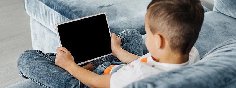 Niño menor navegando en internet con su tablet