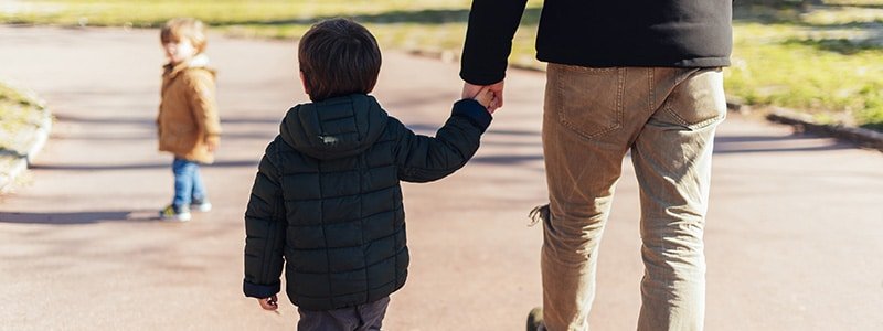 Padre con su hijo caminando por el parque de la mano