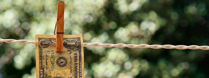 Billete de un dólar colgado en una cuerda con un palillo