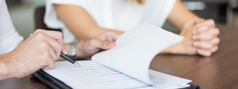 Personas controlando pliego de condiciones de una licitación pública