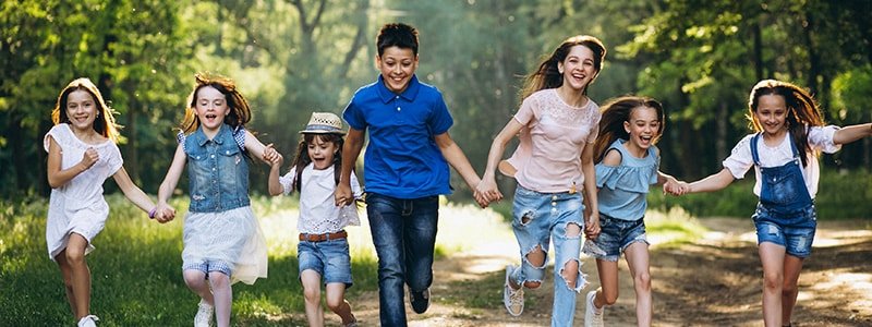 Niños corriendo por un parque de la mano